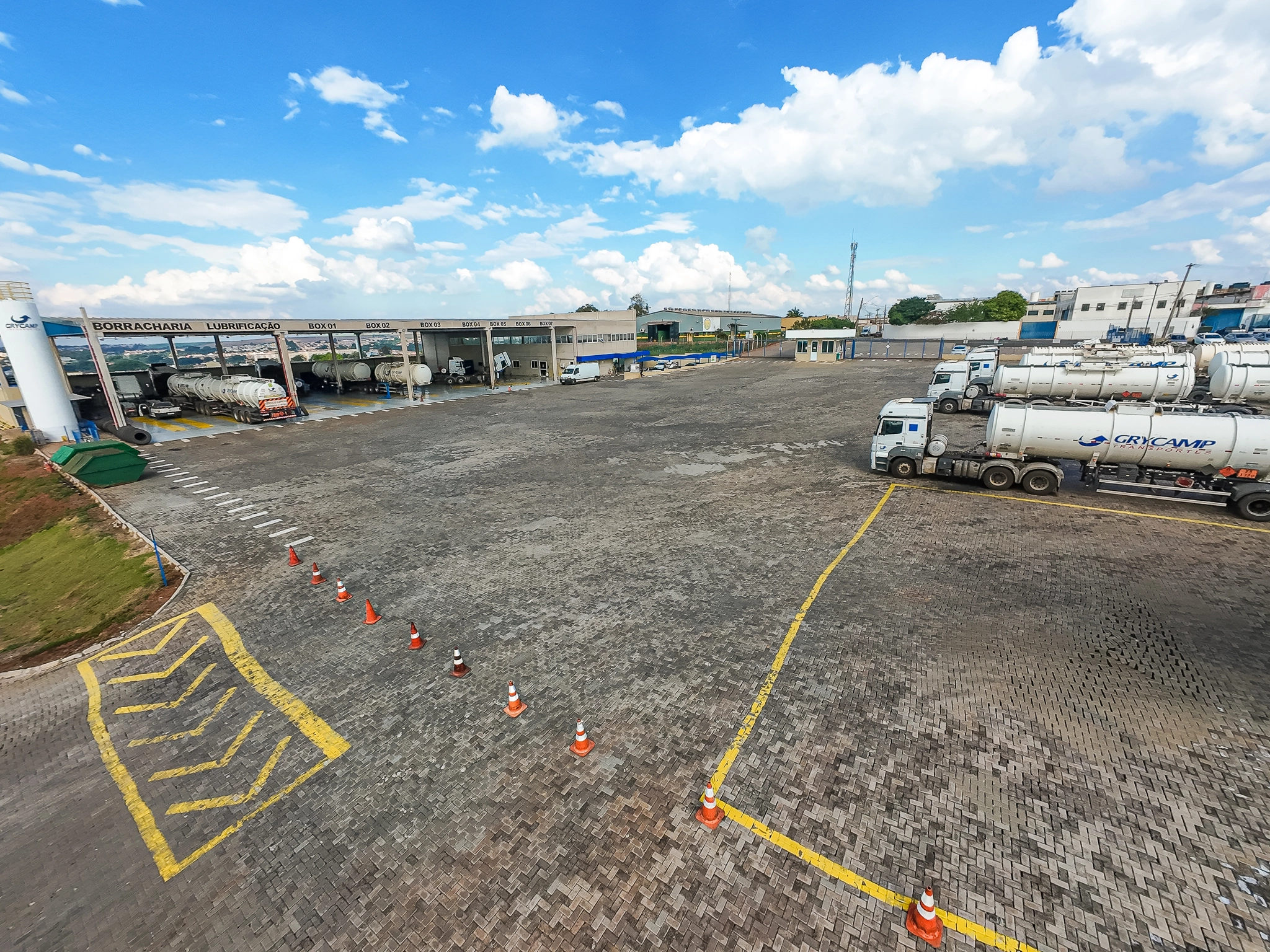 Pátio pavimentado da Grycamp com caminhões tanque estacionados e sinalização no solo