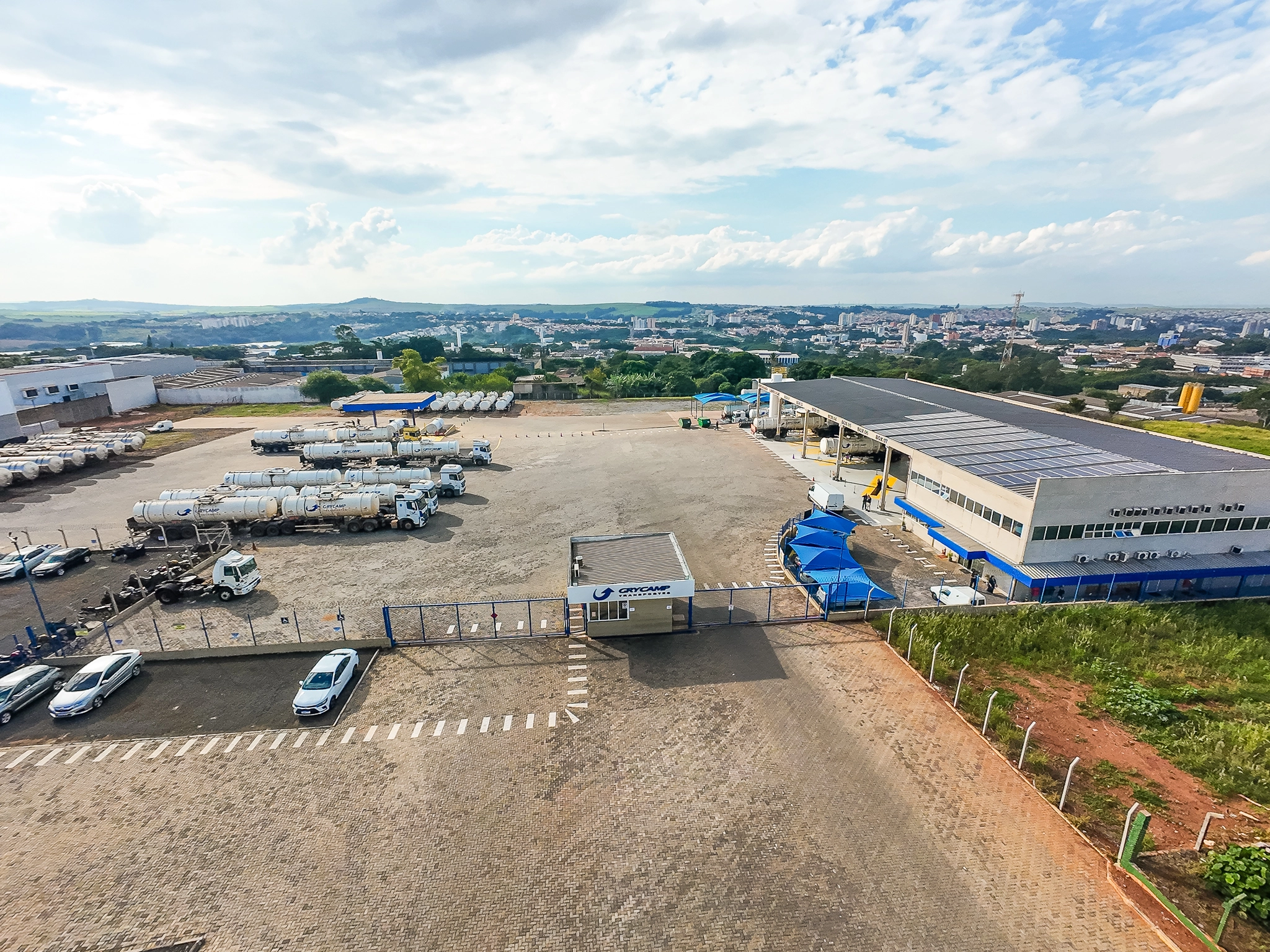 Vista aérea da base Grycamp com prédio administrativo, pátio e caminhões tanque